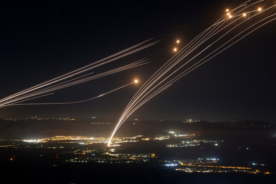 a bunch of lights are flying over a city at night