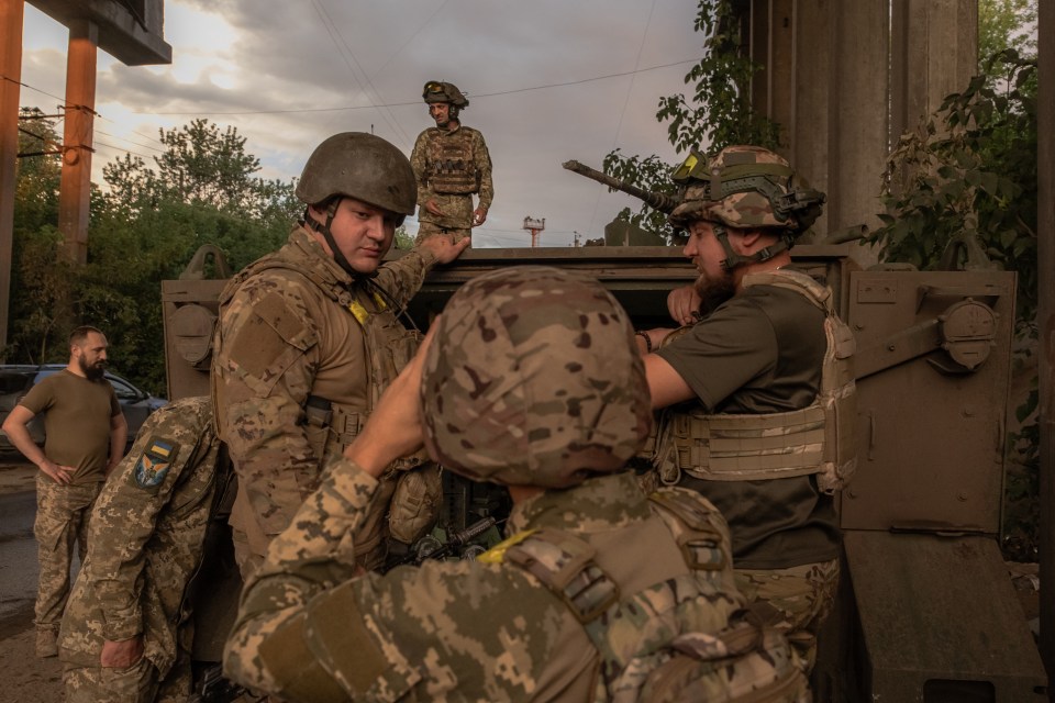 a group of soldiers with one wearing a patch that says ' ukraine ' on it