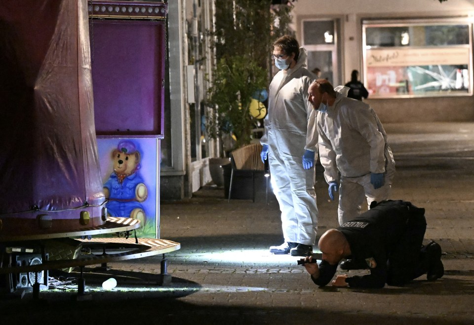 a police officer kneeling down taking a picture of a teddy bear