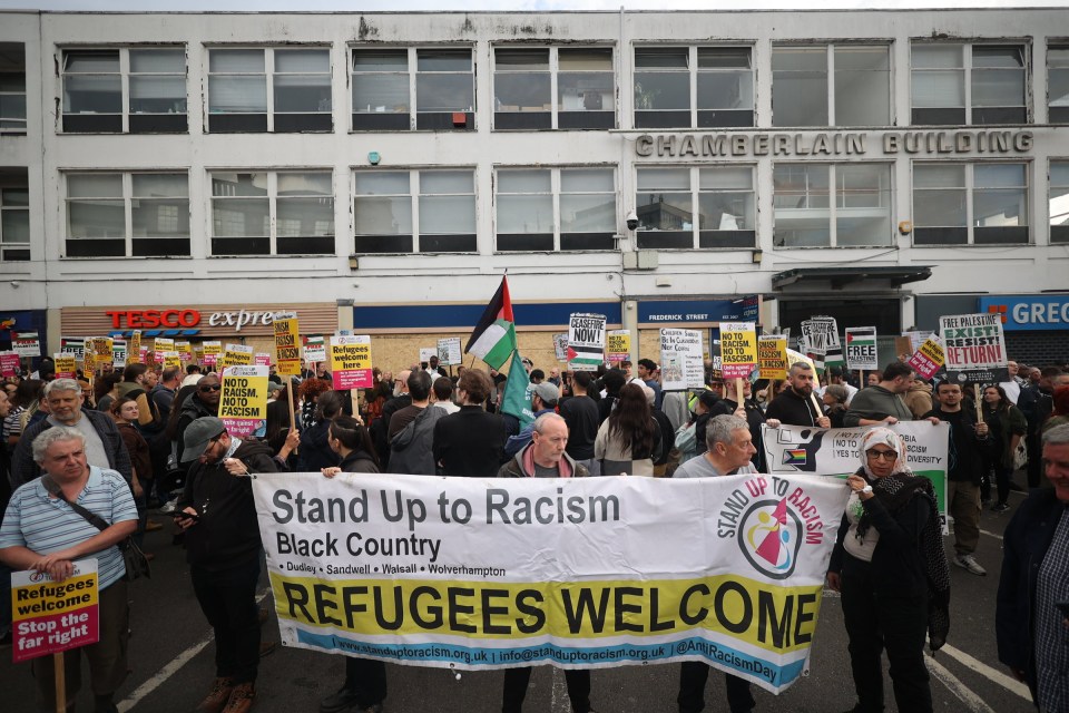 a group of people holding a sign that says refugees welcome