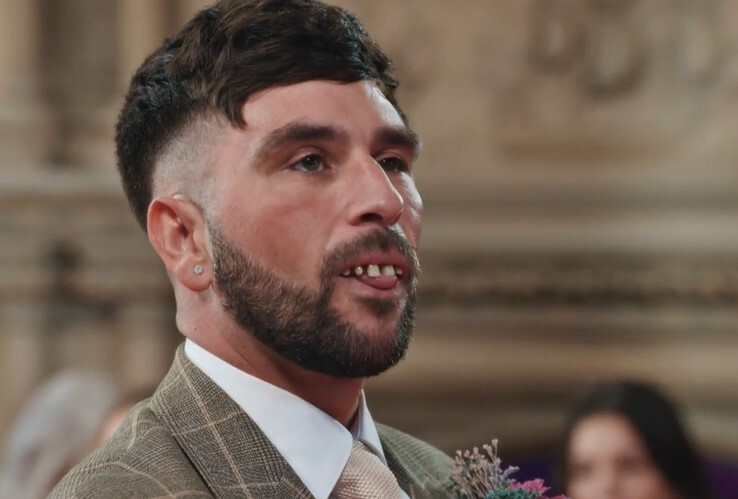 a man with a beard is wearing a suit and tie