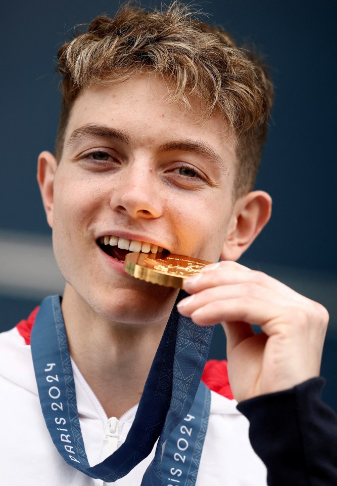 a young man wearing a paris 2024 medal around his neck