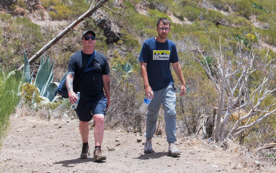 a man wearing a berghaus shirt walks with another man