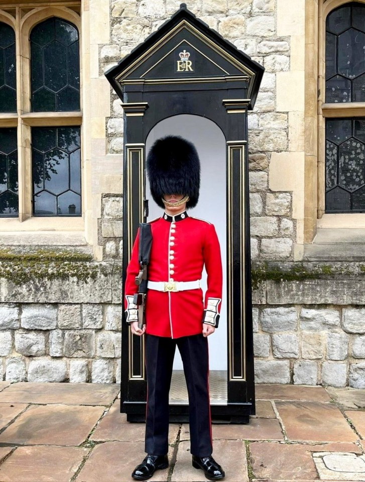 a man in a red uniform is standing in front of a building with the letter er on it