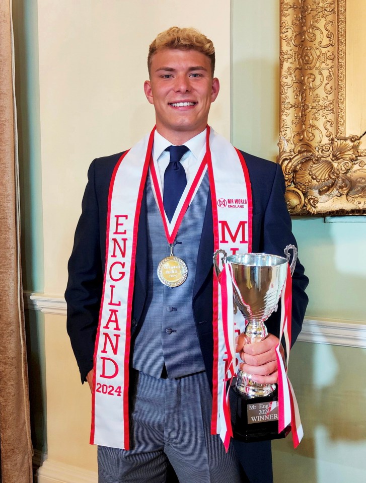 a man wearing a scarf that says england holds a trophy