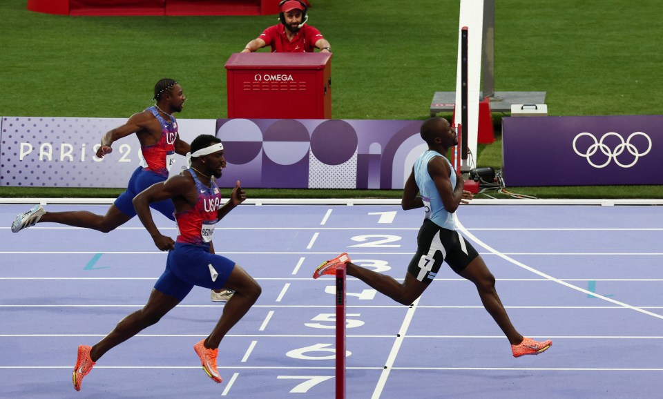 athletes running on a track with a sign that says paris 2