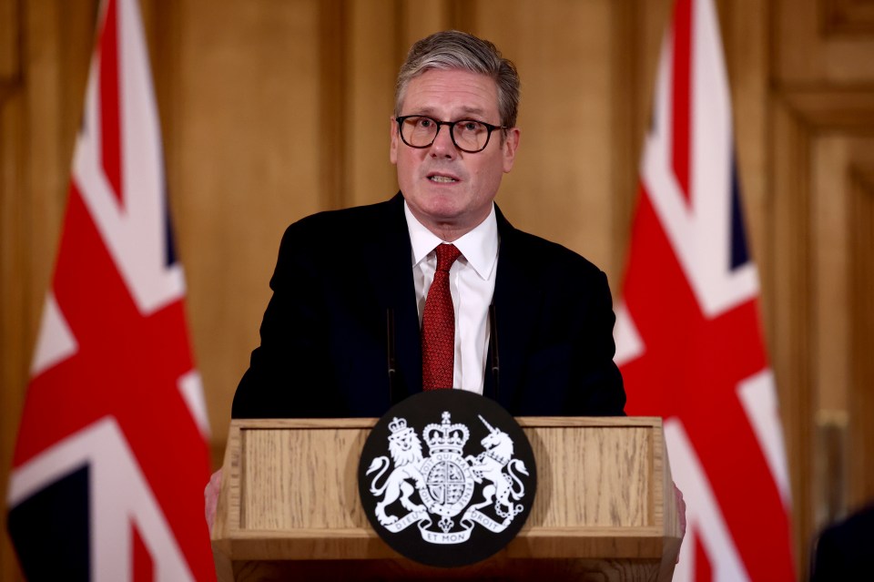 a man stands at a podium with a coat of arms on it