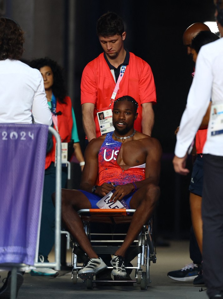 a man in a us shirt sits in a wheelchair