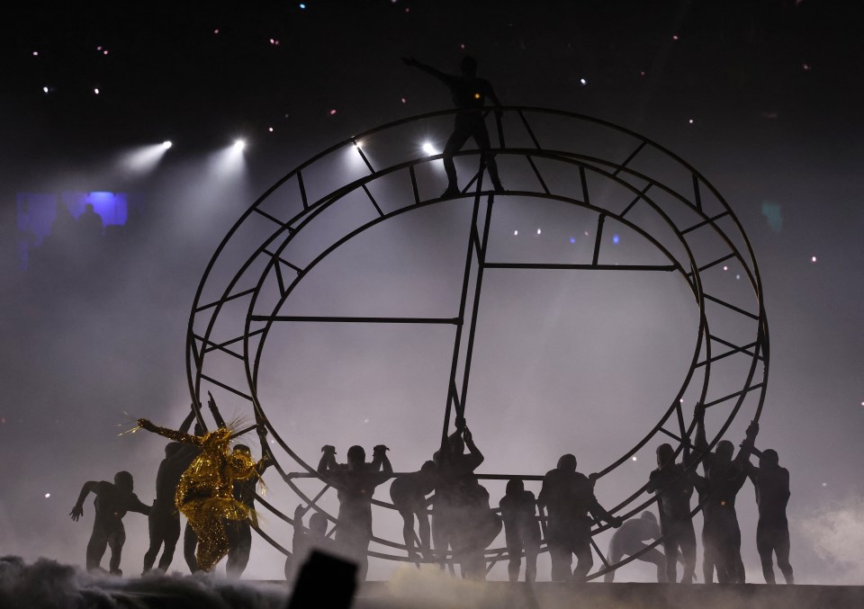 a group of people are standing in front of a ferris wheel