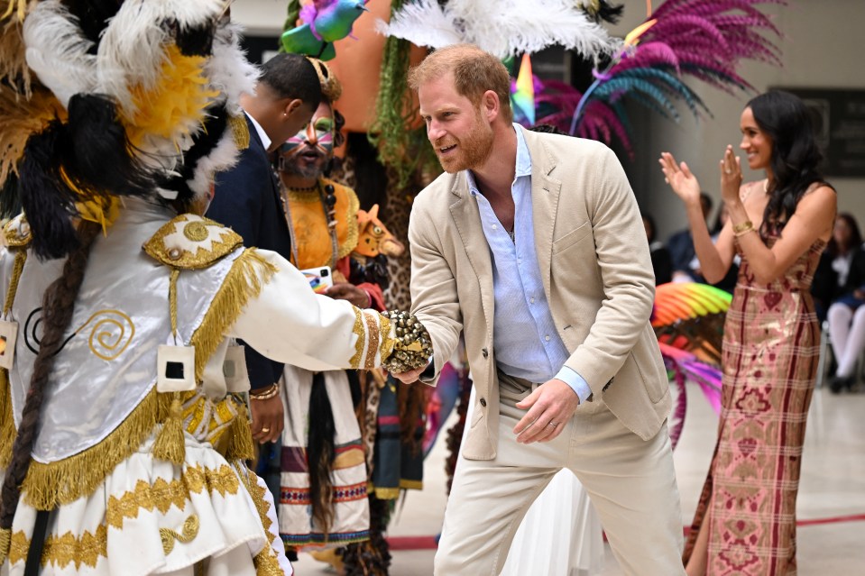 Harry greets a performer after the show, next to his wife Meghan