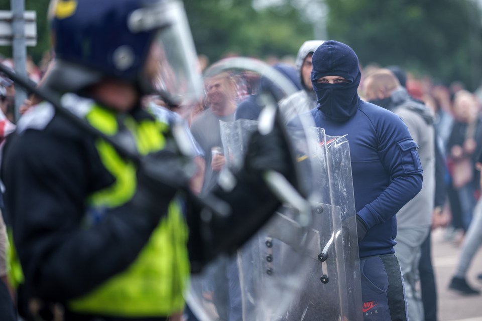 a man wearing a nike shirt stands in front of a police officer