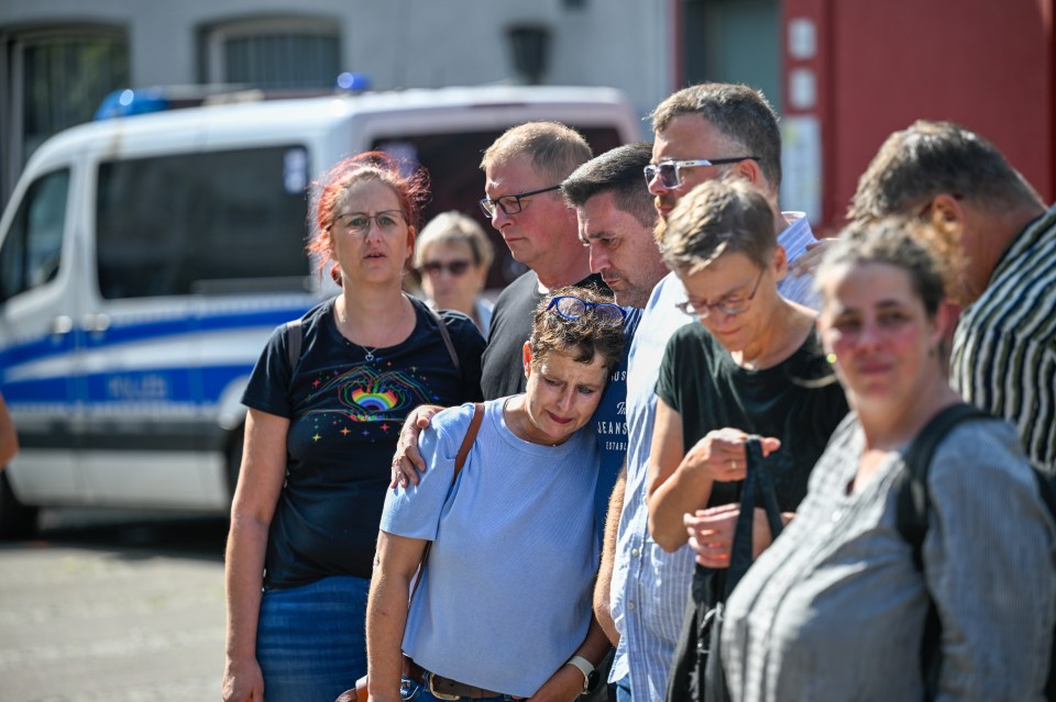 a group of people standing in front of a police van