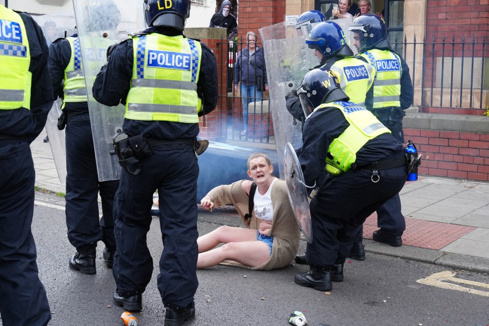 Stacey Vint being detained by police after trying to ram them with a burning bin