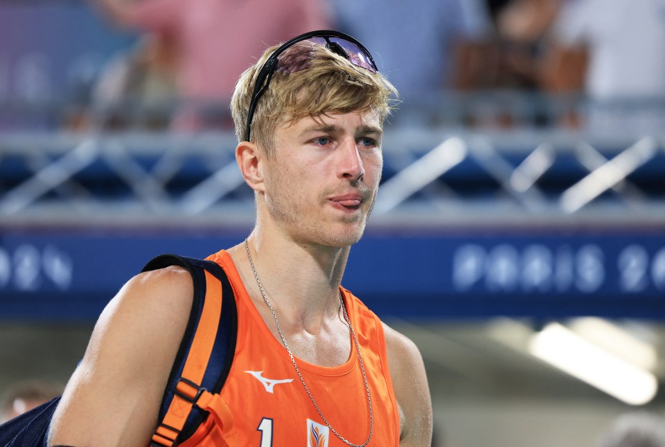 a man wearing an orange tank top with the number 1 on it