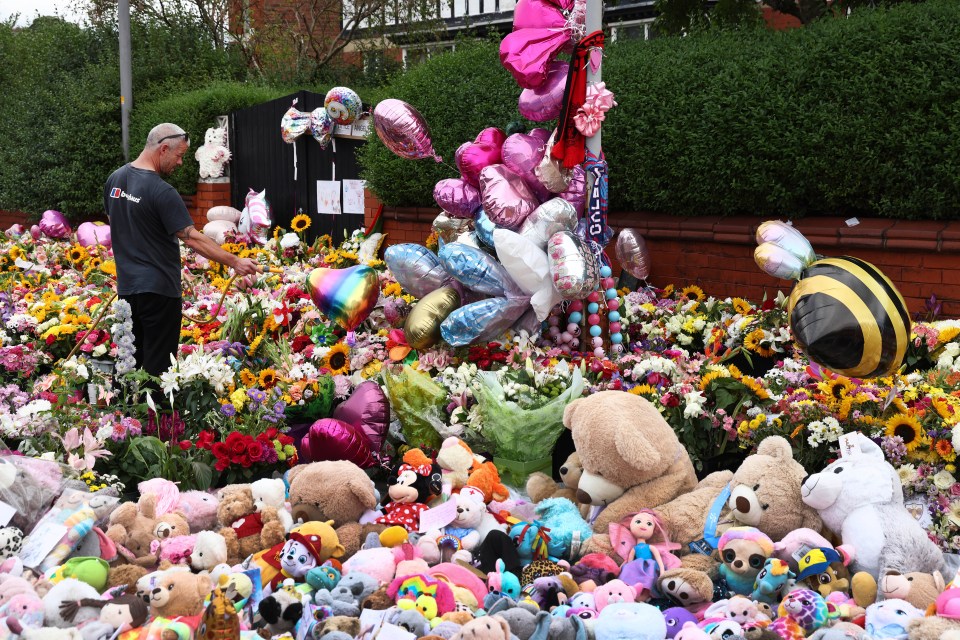 A man waters the floral tribute in Southport