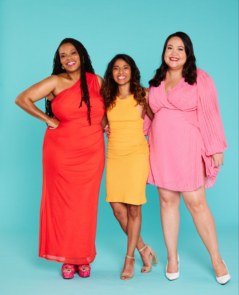 three women posing for a picture with one wearing a red dress