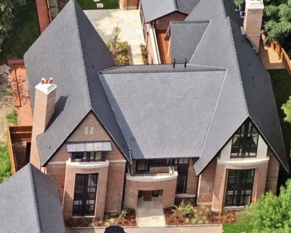 an aerial view of a large brick house surrounded by trees