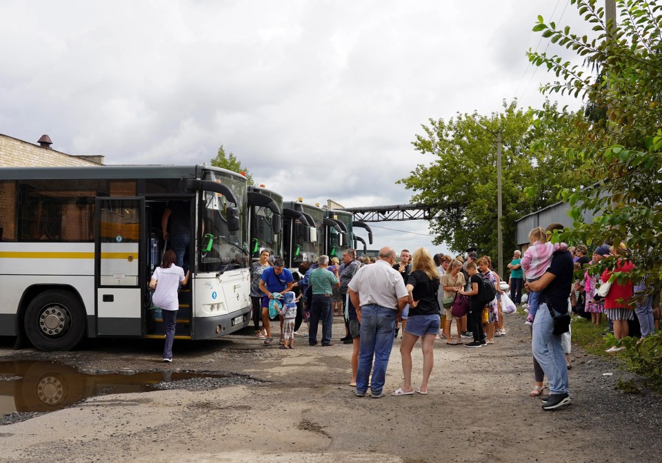 a group of people standing in front of a bus that says tpt