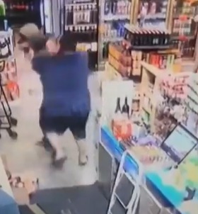 The shop manager tries to fight him off and the pair wrestle on the ground