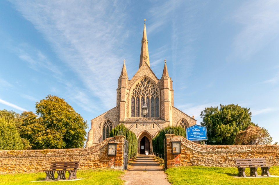 a church with a blue sign in front of it that says ' st. john ' on it