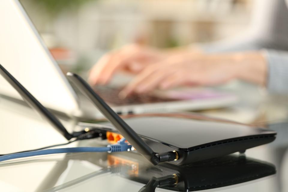 Close-up of a broadband router connected to a laptop.