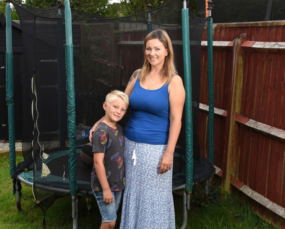 a woman and a boy standing in front of a trampoline