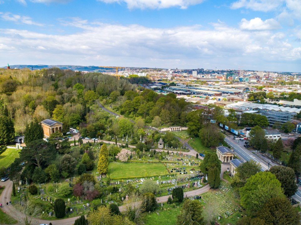 an aerial view of a cemetery with a city in the background