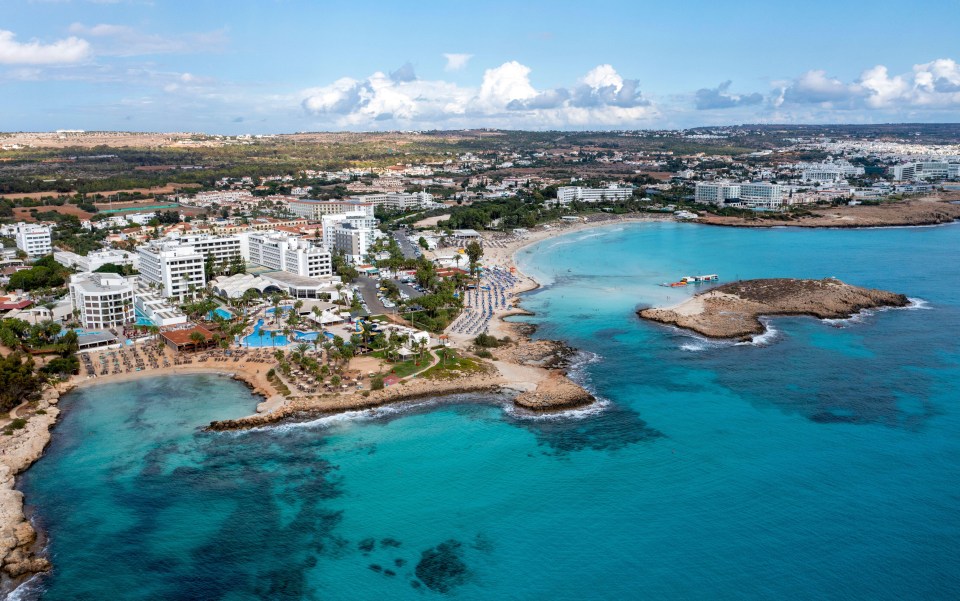 an aerial view of a beach with a city in the background