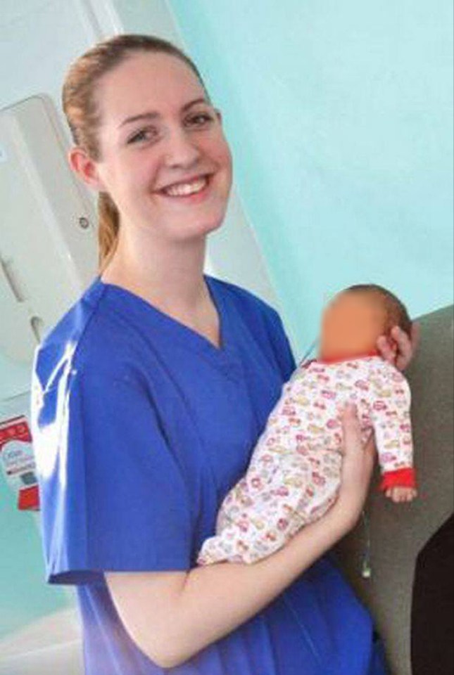 a nurse is holding a baby in her arms and smiling .