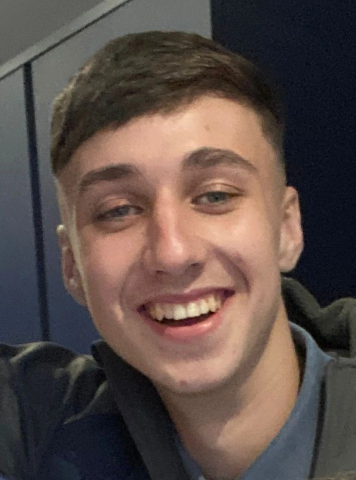 a young man in a blue shirt smiles for the camera