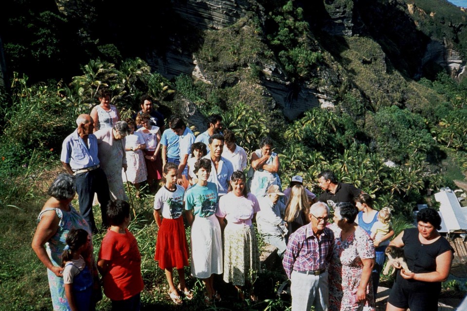 a group of people standing on top of a hill in the pitcairn islands