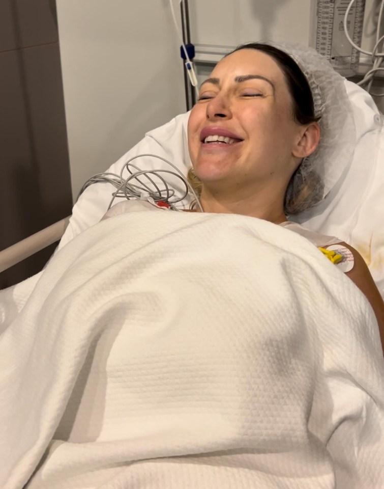 a woman is laying in a hospital bed and smiling