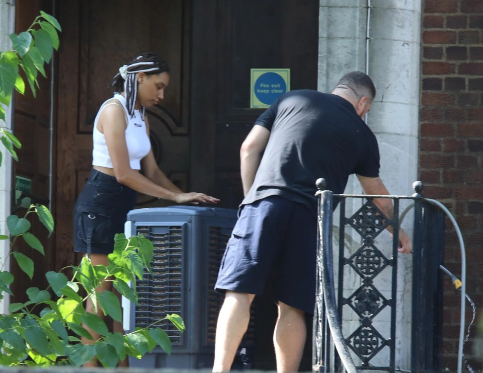 a man and a woman standing in front of a fire exit sign