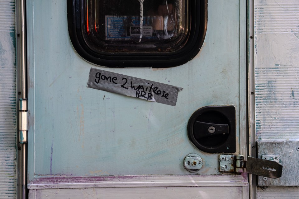 A message is left on the door of a caravan that is parked on the roadside