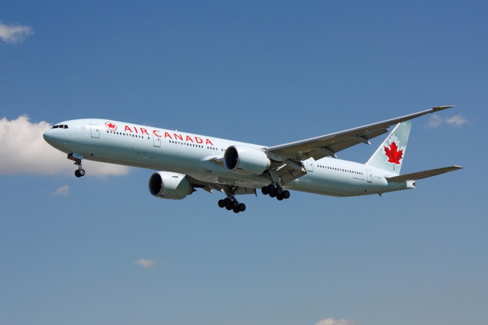 an air canada plane is flying in the sky