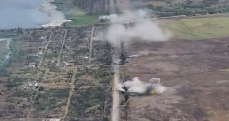 a helicopter is flying over a field with smoke coming out of it .