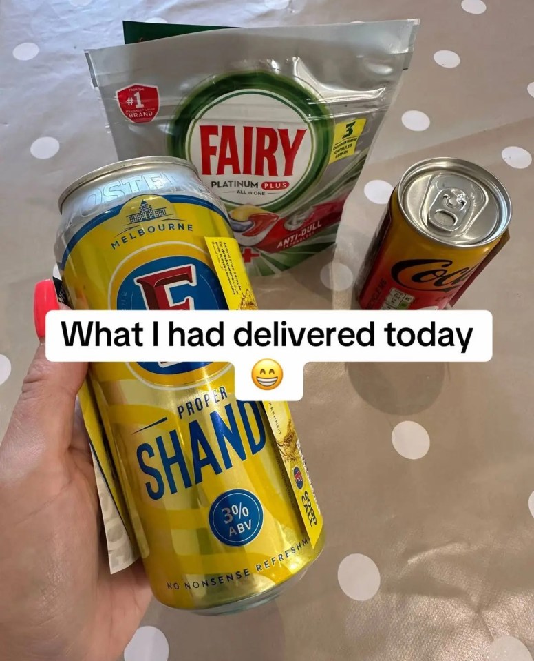 a person holding a can of shand beer next to a bag of fairy dishwasher detergent