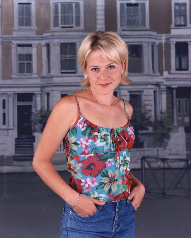 a woman in a floral tank top stands in front of a house