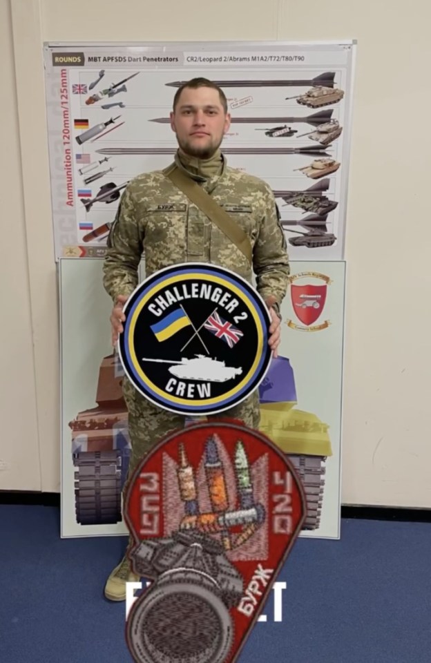 a man in a military uniform holds a challenger 2 crew sign