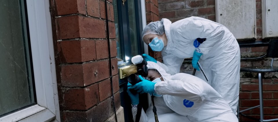 The forensic team examine the door to the flat