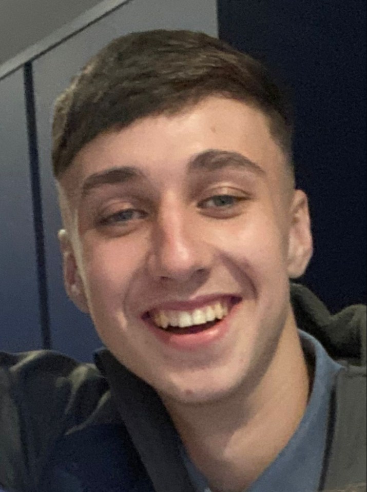 a young man in a blue shirt smiles for the camera