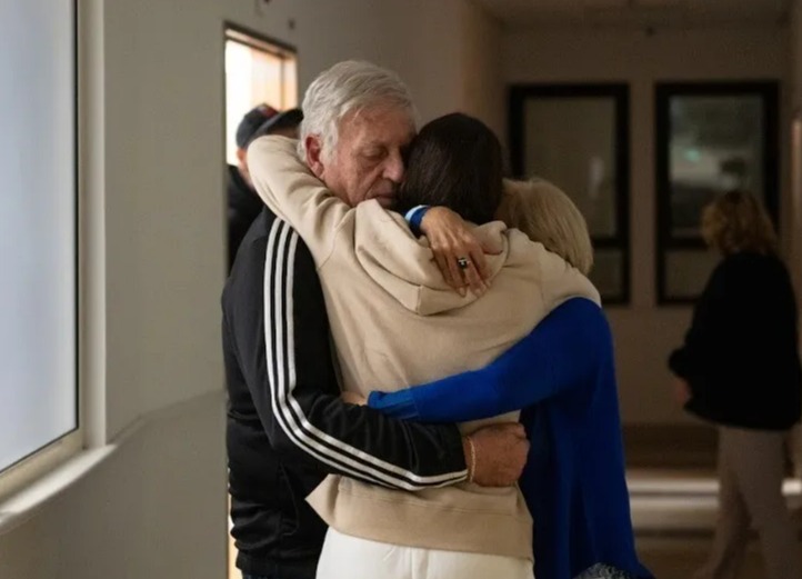 a man and woman hugging each other in a hallway