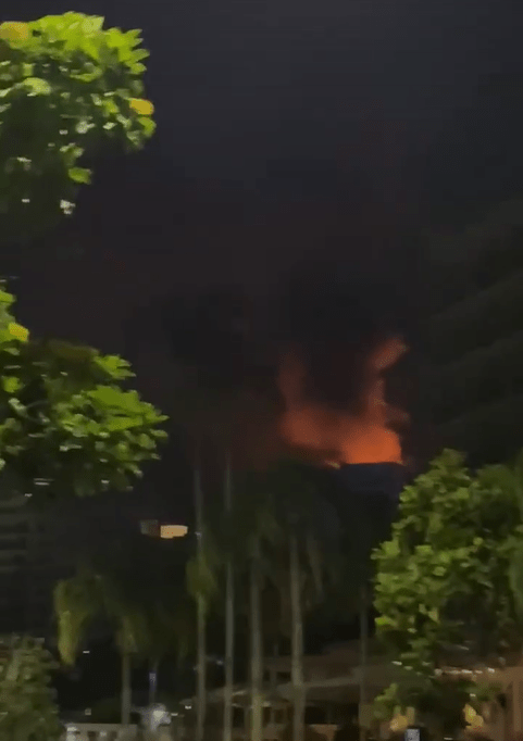 A clip shows red fire lighting up the top of the building