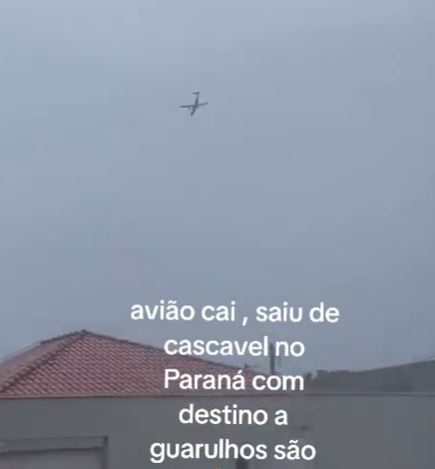 a plane is flying in the sky above a house .