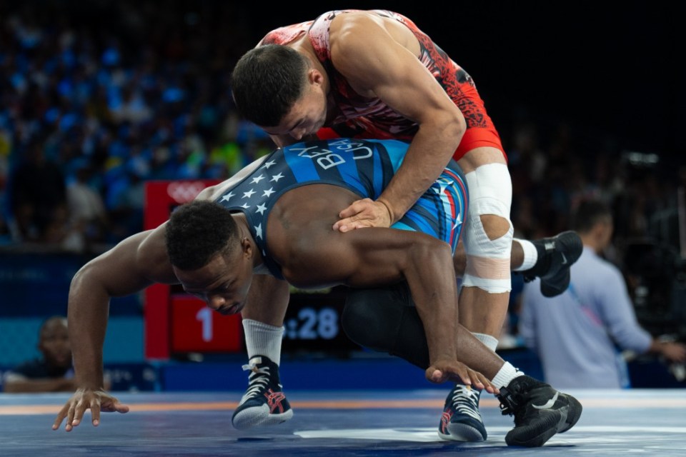 PARIS, FRANCE - AUGUST 06: Akzhol Makhmudov (red) of Kyrgyzstan and Kamal Ameer Bey (blue) of United States in their men's greco-roman 77kg wrestling early rounds match at the Champ-de-Mars Arena during the Paris 2024 Olympic Games, in Paris, France on August 6, 2024. (Photo by Aytac Unal/Anadolu via Getty Images)