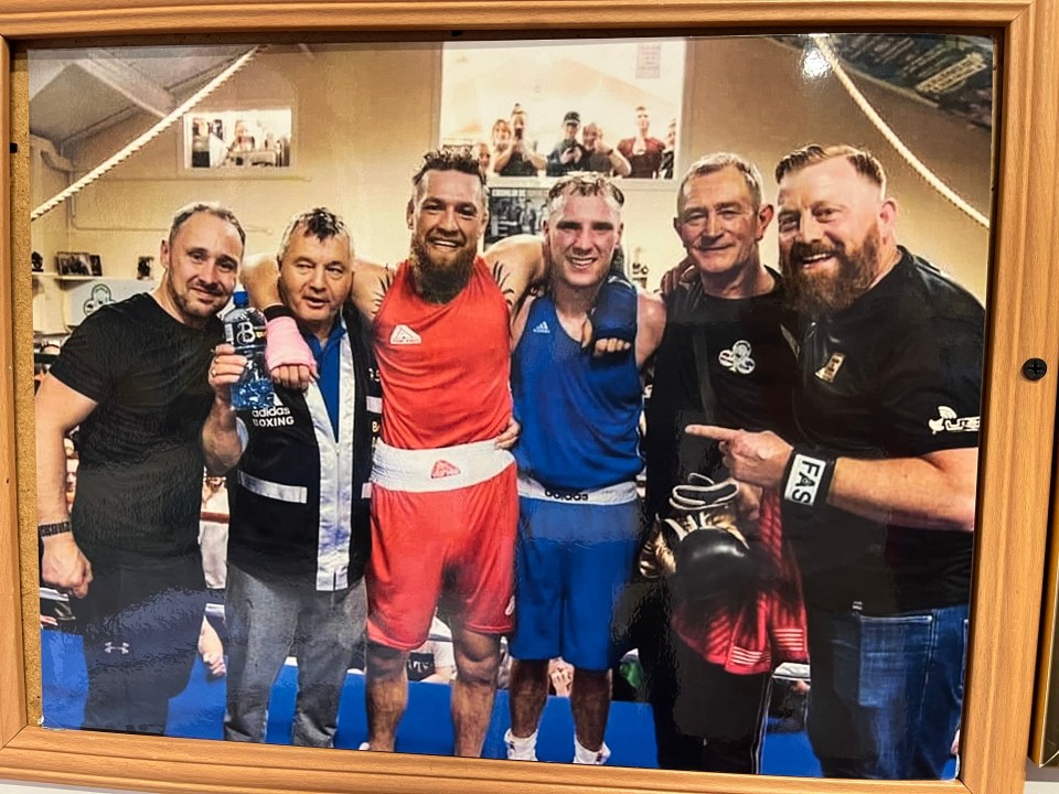 a group of men posing for a picture with one wearing an adidas shirt