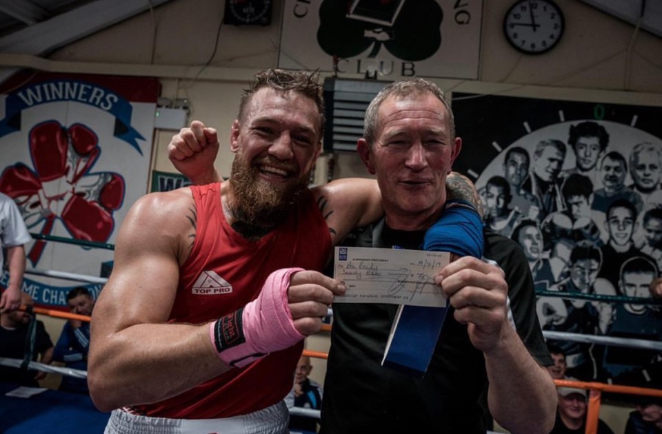 a man in a red top pro tank top holds a check