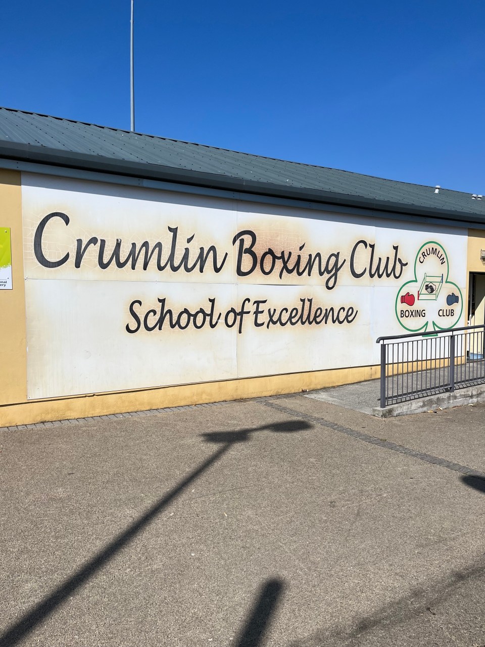 a sign on the side of a building says crumlin boxing club school of excellence