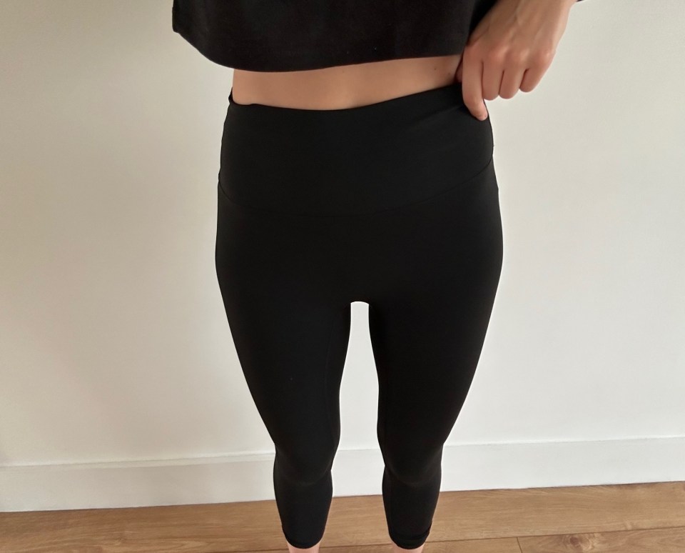 a woman is wearing black leggings and a black crop top