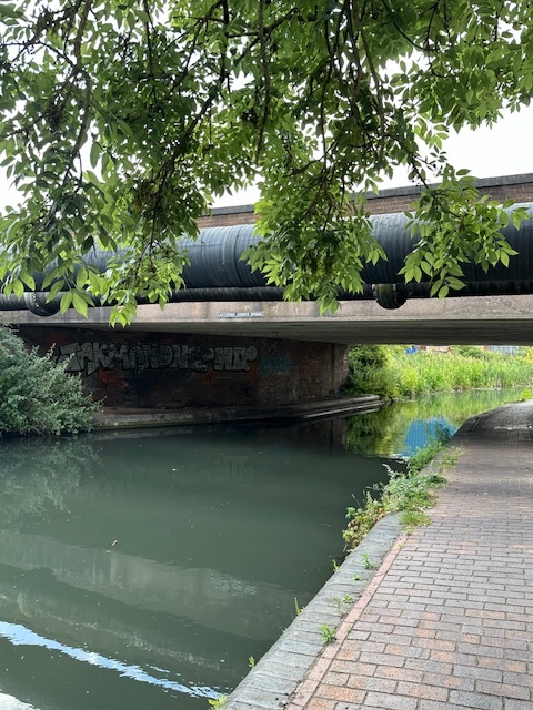 a bridge over a body of water with graffiti on it